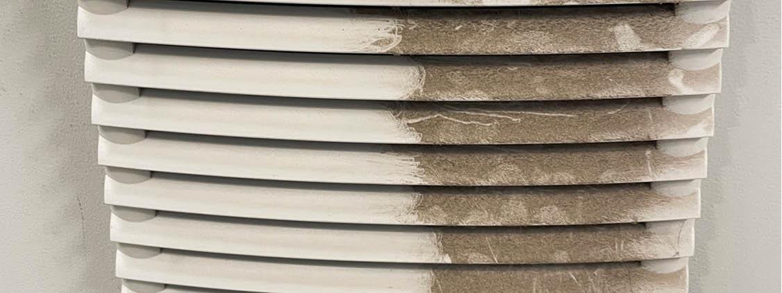 Dust-clogged ventilation filter restricting airflow in industrial equipment.